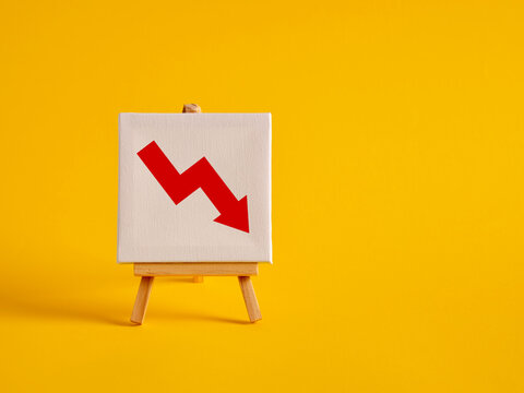 A canvas with decreasing graph symbol on an easel with yellow background