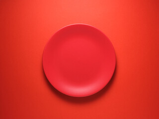 Food background. Empty ceramic red plate on red background.