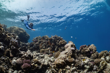 free diver woman diving on coral reef in the sea