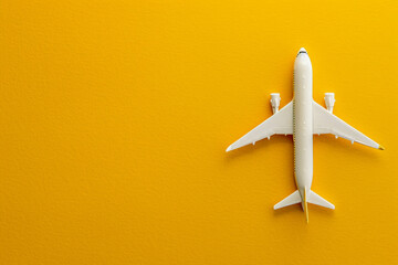 Travel Dreams in Bold Contrast: A white model airplane lies centered against a vibrant yellow background, symbolizing adventure and exploration