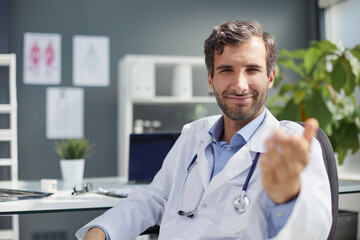 A male doctor in a white coat looks at the medical history and laughs. - obrazy, fototapety, plakaty