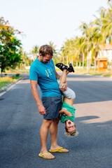 Father son have fun. Man holds child's leg upside down head. Joy happiness childhood paternity...