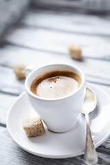 Cup of coffee on bright wooden background. Soft focus. Close up. Copy space.