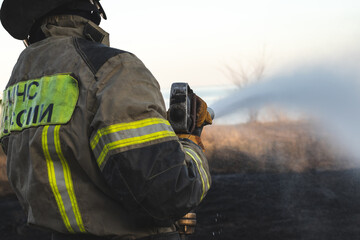 Fireman extinguishing a fire on a field