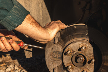 Men's hands repair of car drum brake himself.