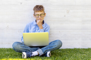 A boy using a laptop outdoors - 755400988