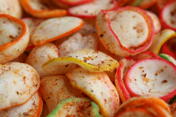 Background texture of kerupuk seblak, is colorful round crackers with spicy chili powder topping