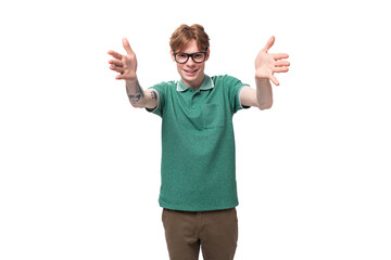 a young stylish man with red hair in a green T-shirt wants to tell interesting news and actively gesticulates