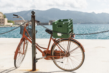 Old bicycle standing near the sea at sunny day Italian seaside.