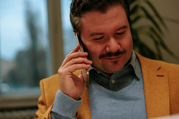 Man working and talking on his phone while smirking