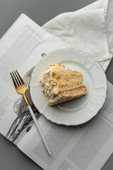 A slice of nut cake on the coffee table with a golden fork.