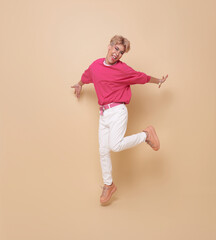 happy smiling youth asian transgender LGBT jumping isolated on nude color background. People lgbt lifestyle fashion concept.