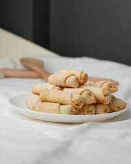 Home baking, sweet mini tube-shaped cookies with coffee.