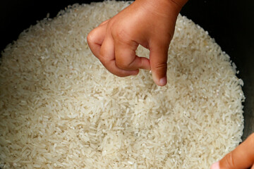 Child's hand carrying a pile of rice in hand for zakat, Islamic concept of zakat. Muslims to help...