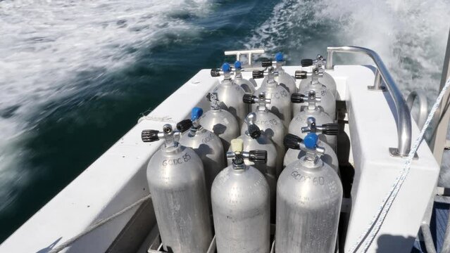 Scuba diving tanks secured on a dive boat travelling to the Great Barrier Reef.
