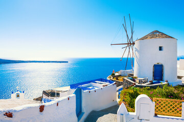 White architecture in Santorini island, Greece. Windmill in Oia town at sunny day. - obrazy, fototapety, plakaty