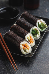 Black Plate With Sushi, bowl of soy sauce and Chopsticks