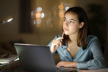 Tele worker in the night thinking and working at home - 755437918