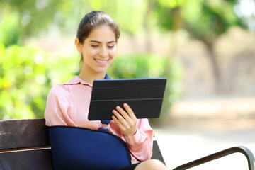 Convalescent woman watching tablet content in a garden