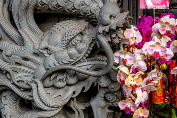 Ornate gray figurine with colorful orchids at the Songshan Ciyou Buddhist Temple in Taipei © Rex Wholster
