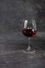 glass of red wine on dark stone background