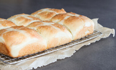 Fresh baked hot cross buns in a baking rack 