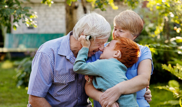 Cheerful boy playing with grandparents in garden