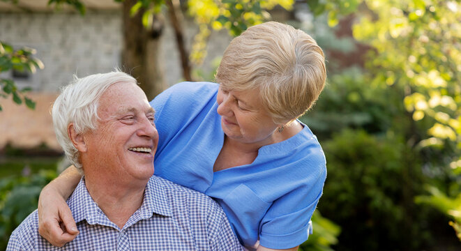 Happy senior man spending leisure time with woman in garden