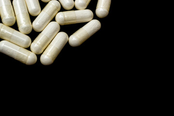 White capsules, pills on a black background with place for text. Medicine, healthcare concept....