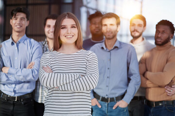 Smiling businesswoman looking at camera together with colleagues