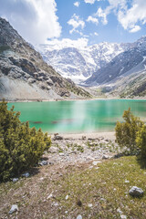 Obraz premium Blue lake Kulikalon against the backdrop of rocky mountains with glaciers in the Fan Mountains in Tajikistan, mountain panorama and turquoise lake