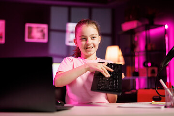 Child influencer filming wireless mechanical keyboard review in studio, showing capabilities and...