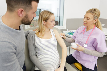doctor vaccinating pregnant woman in clinic