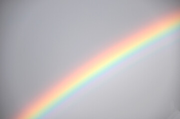 Bunter Regenbogen am Himmel: Ein Wetterereignis mit kreisbogenförmigen  Lichtspiel und optisches Phänomen bei Regen mit Sonne gleichzeitig
