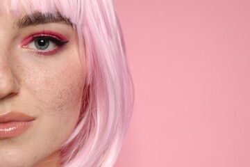 Fototapeta premium Beautiful woman with bright makeup and fake freckles on pink background, closeup. Space for text