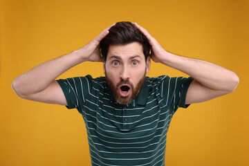 Portrait of surprised man on yellow background