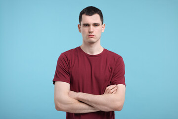 Portrait of sad man on light blue background