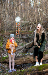 Mother and daughter are setting up decorations for an outdoor photo session, spring day in forest