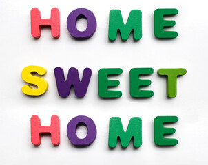 Home Sweet Home - phrase. Words made from colorful wooden letters isolated on white background.