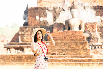 Girl visiting Ayutthaya Thailand at Wat Mahathat, women with a hat and tourist map visiting Ayutthaya Thailand.