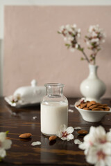 Almond milk with almonds and almond blossoms on the table: the vegan alternative to traditional milk