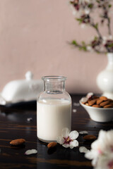 Almond milk with almonds and almond blossoms on the table: the vegan alternative to traditional milk