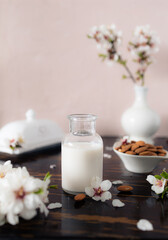 Almond milk with almonds and almond blossoms on the table: the vegan alternative to traditional milk