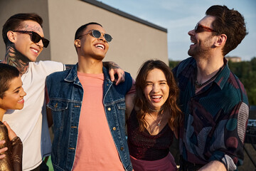 good looking diverse joyous friends with sunglasses having great time together at rooftop party