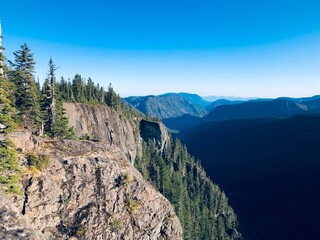 Person standing on edge of cliff looking out on canyon