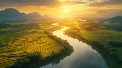 Wandaufkleber Golden sunset over tranquil river flowing through lush rice fields © Robert Kneschke
