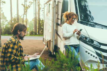 Adult couple of traveler enjoy outdoors leisure activity together outside a modern motorhome camper...