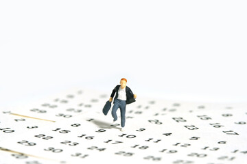 Miniature people toy figure photography. A boy pupil student running above calendar. Isolated on a...