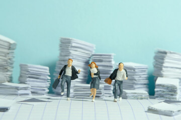 Miniature people toy figure photography. Homework concept. The group of pupil students running on...
