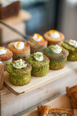 Decorated muffins are arranged on the counter of a coffee shop. Side view. Selective focus